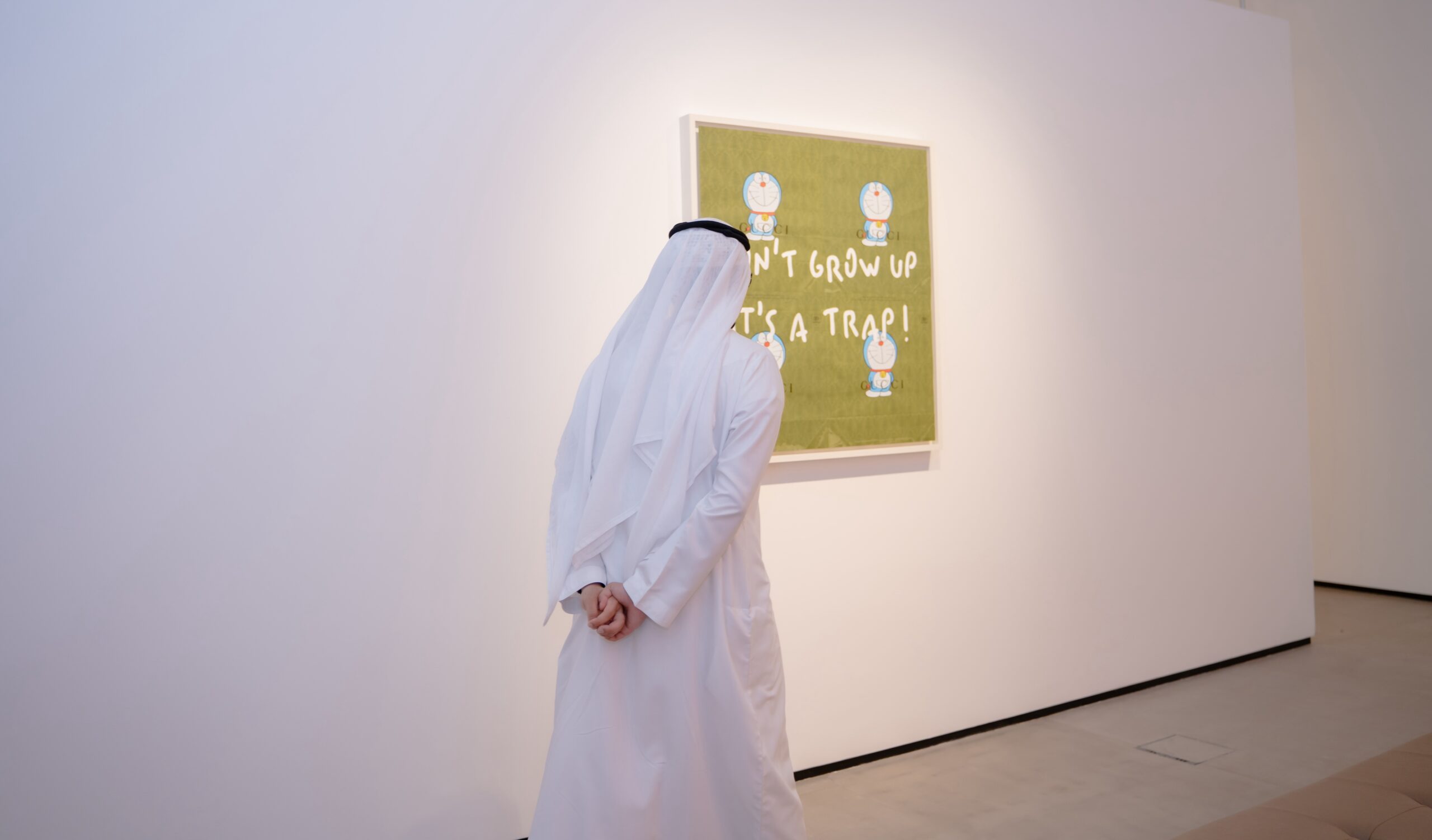 A collector viewing a contemporary artwork in a Dubai gallery, United Arab Emirates